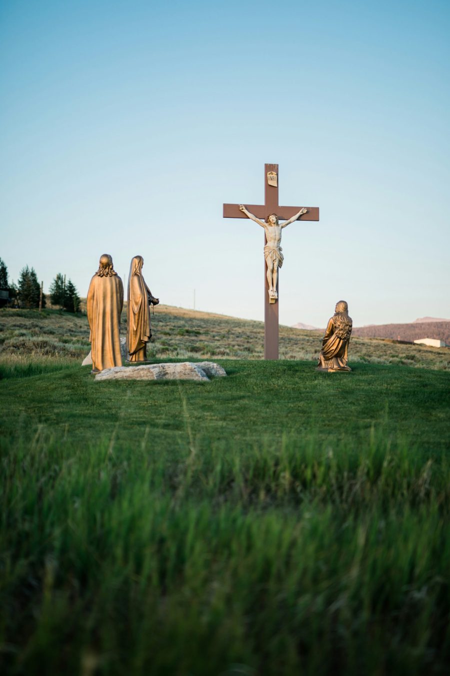 A crucifix statue of Jesus Christ, surrounded by other religious figures and sculptures.