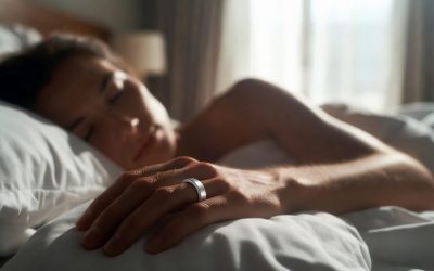 Sleek minimalist titanium smart ring on a person’s finger while peacefully sleeping in a bright modern bedroom – stylish wearable sleep tracker.