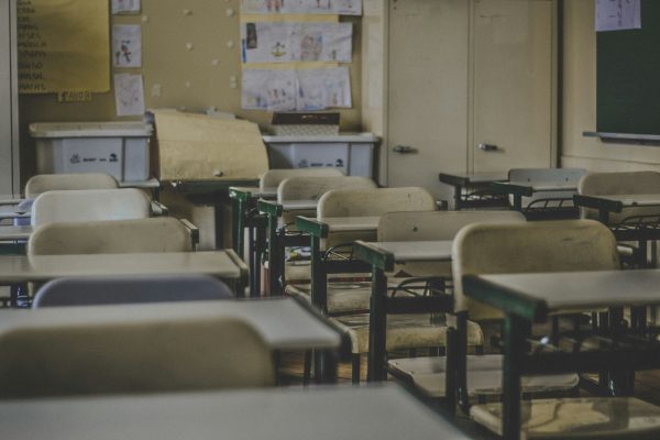 Empty classroom with rows of student desks and chairs.