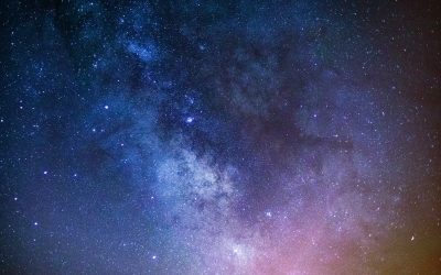 Night sky showing the Milky Way as a dense river of stars, colored blue, purple, and pink.